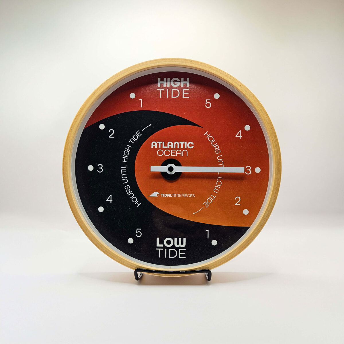 Front view of tide clock sitting in stand.