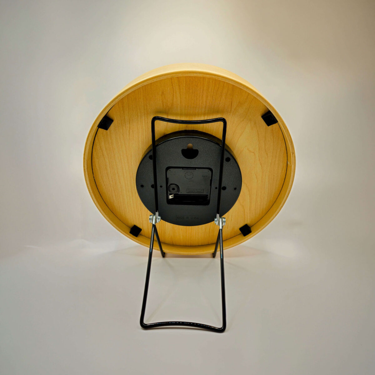 Rear view of tide clock sitting in stand.