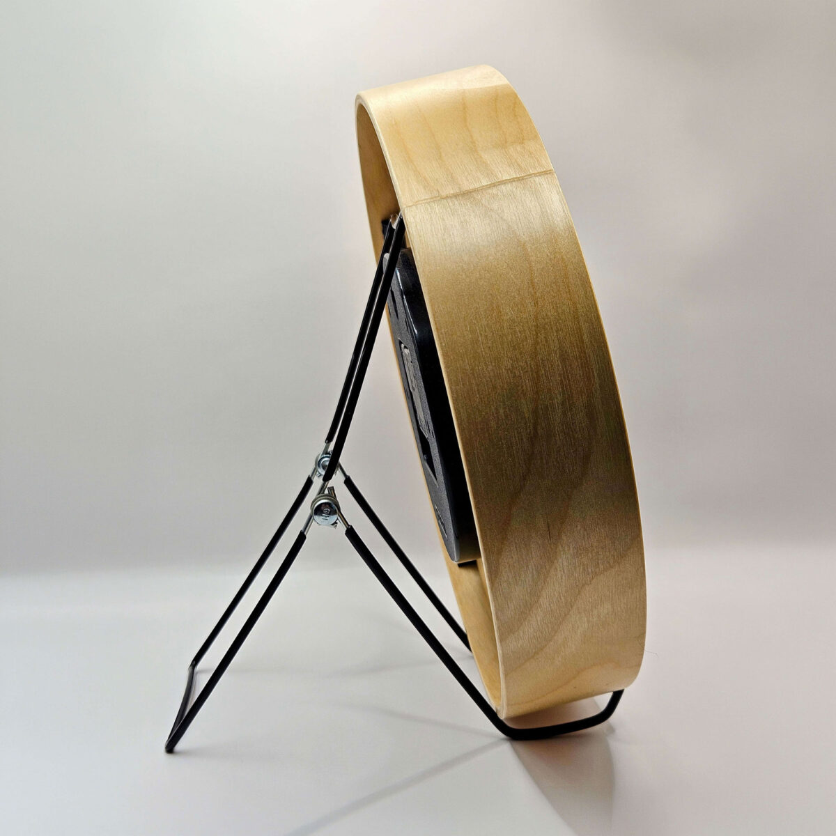 Side view of tide clock sitting in stand.